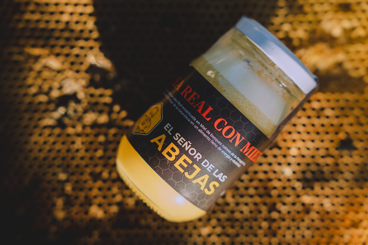 Frasco de Jalea Real con Miel de El Señor de las Abejas sobre un marco de panal